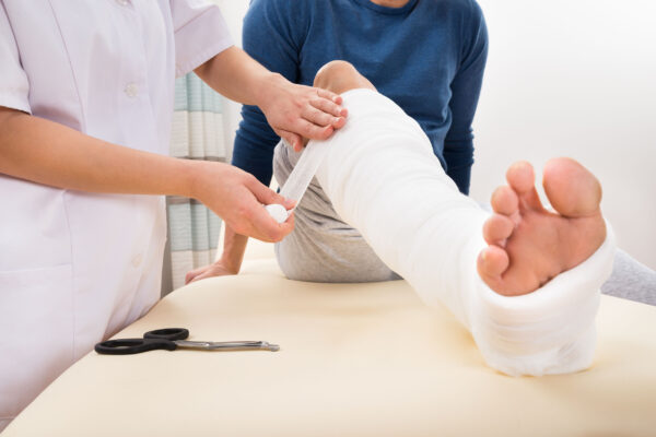 Close-up,Of,A,Female,Doctor,Bandaging,Patient's,Leg Close-up Of A Female Doctor Bandaging Patient's Leg